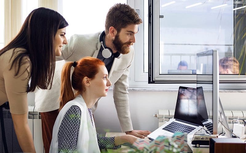 Equipe de travail mixte autour d'un ordinateur